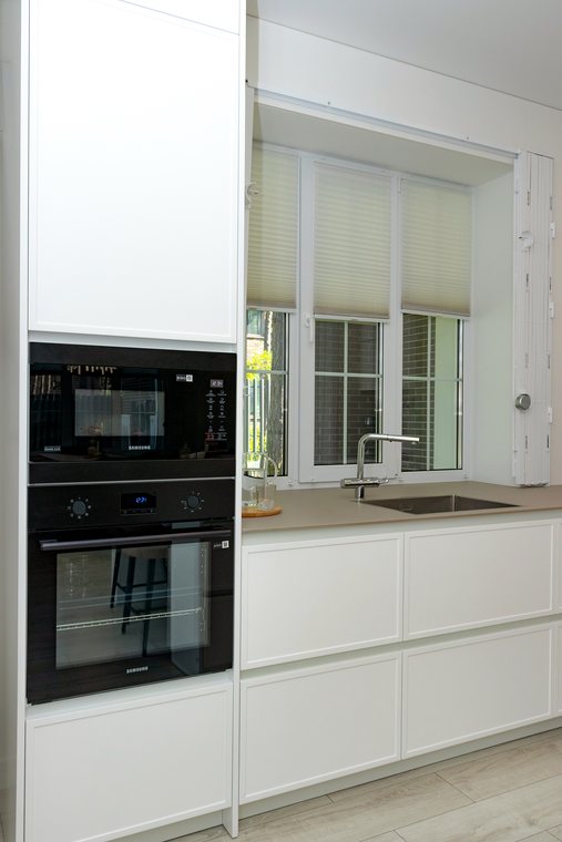 Hochschrank mit Backofen und Mikrowelle neben der Spülzeile
