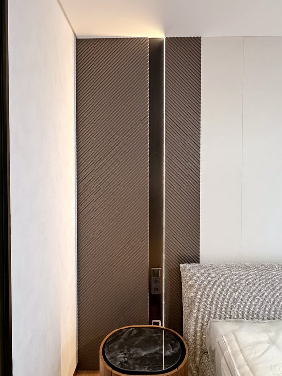 Wandpaneele mit diagonalen Rillen hinter dem Bett
