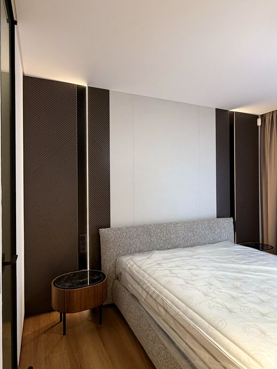 Schlafzimmer mit Wandpaneelen und indirekter Beleuchtung