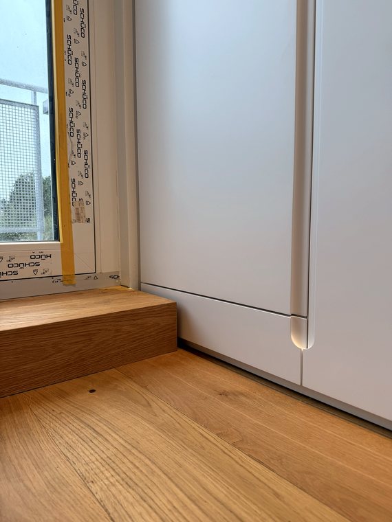 Einbauschrank auf Podest mit Griffmulde, Detail am Boden