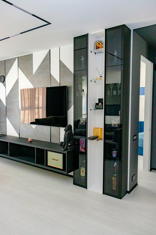 TV-Wand mit Glasvitrinen und geometrischen Paneelen