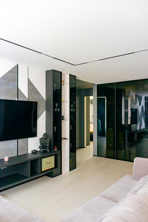Wohnzimmer mit TV-Wand und Vitrine in Rauchglas