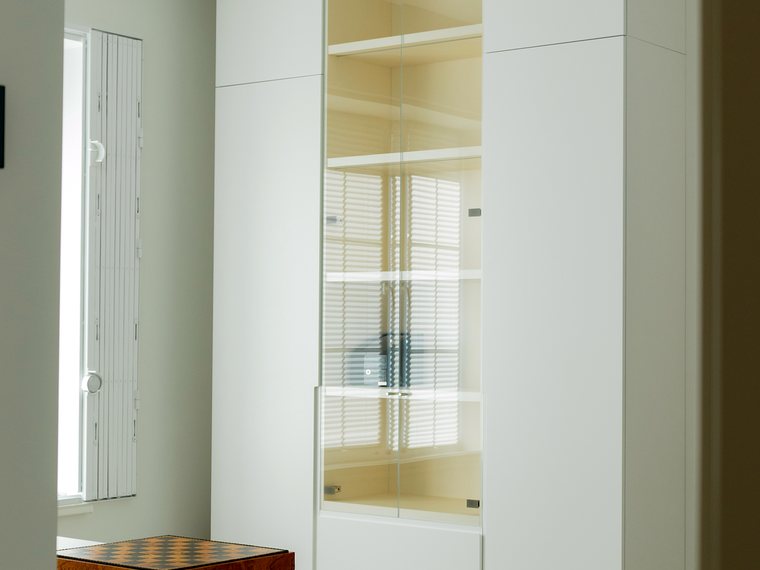 Weißer Einbauschrank mit beleuchteter Glasvitrine